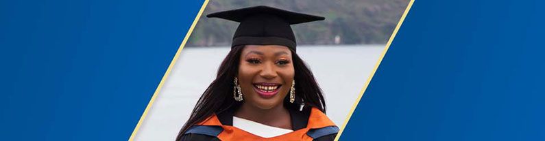 A female student wearing graduation hat and smiling