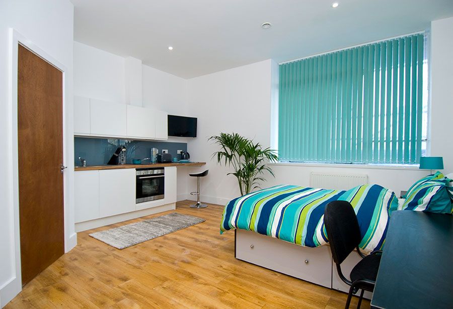 Luxury studio apartment room having bed, tv, and chair