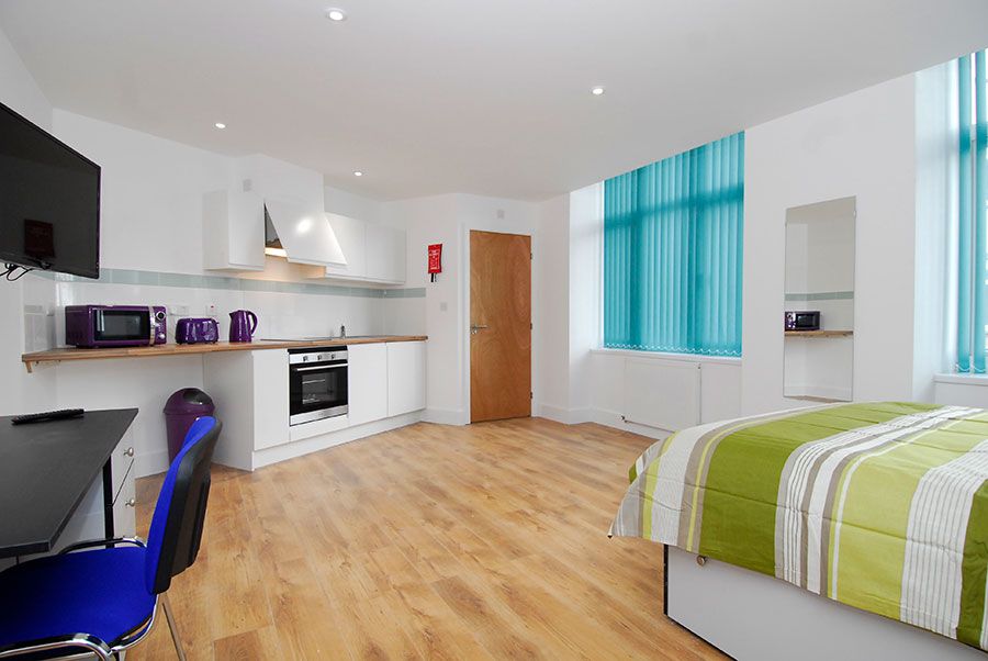 Luxury studio apartment room having bed, tv and computer table
