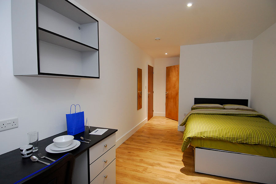 Premium en-suite room having bed and wall shelf