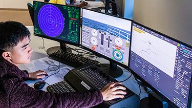 Male student using a ship simulator