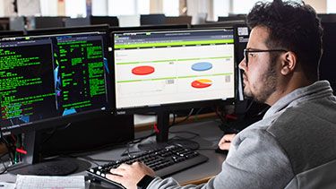 Male student coding on computer