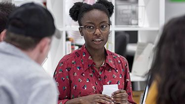 Female student taking to a group of students