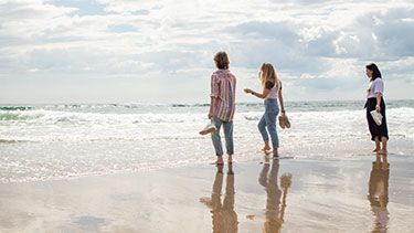 Students looking out to sea on coastal beach