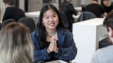 Female student talking in a group of other students