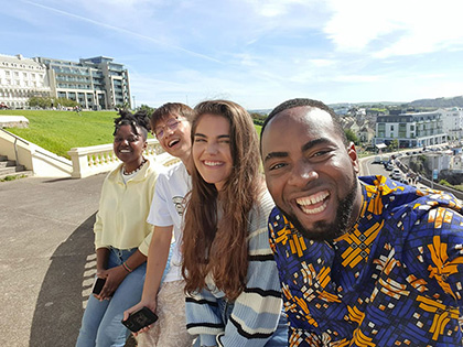 Students are sitting on the road side and laughing